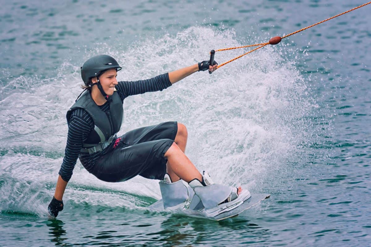 Wakeboarder touching water with hand