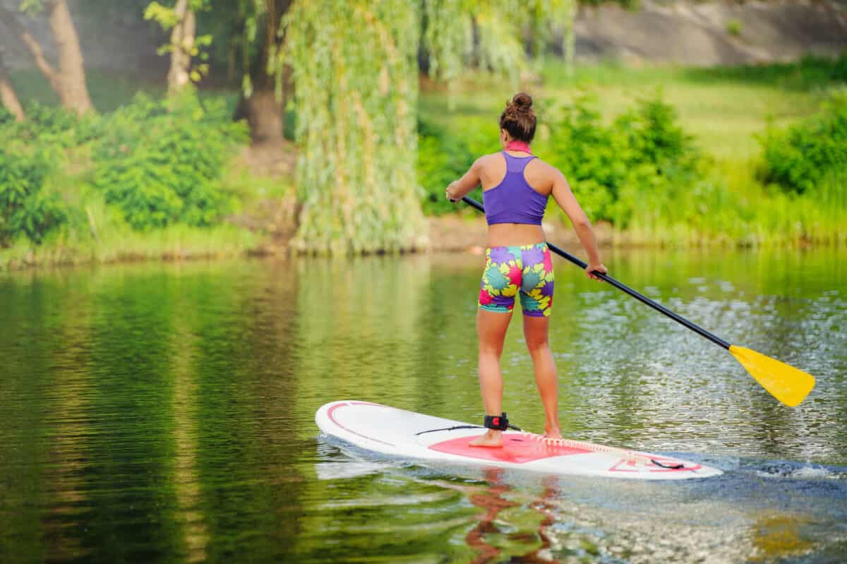 Young athletic woman on a touring paddle board